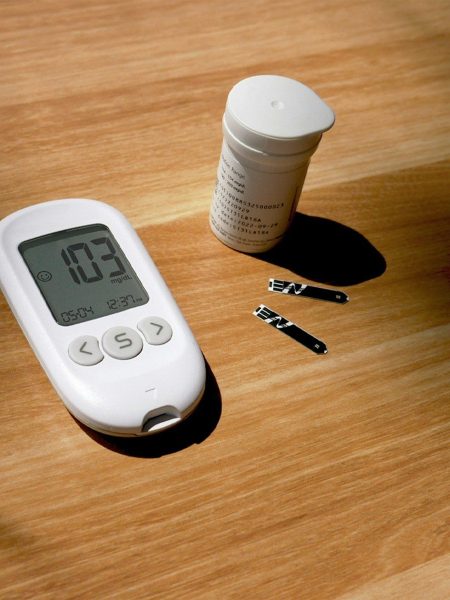 a thermometer, pills, and a bottle on a table